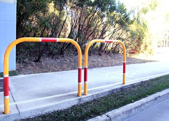 cast in bollards on footpath with yellow and red finish
