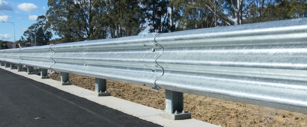 Thrie Beam barrier on road near trees and homes