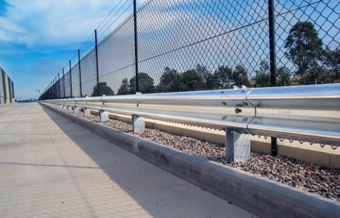 RHINO-STOP® Type 3 parking barrier systems installed around warehouse near chain fencing
