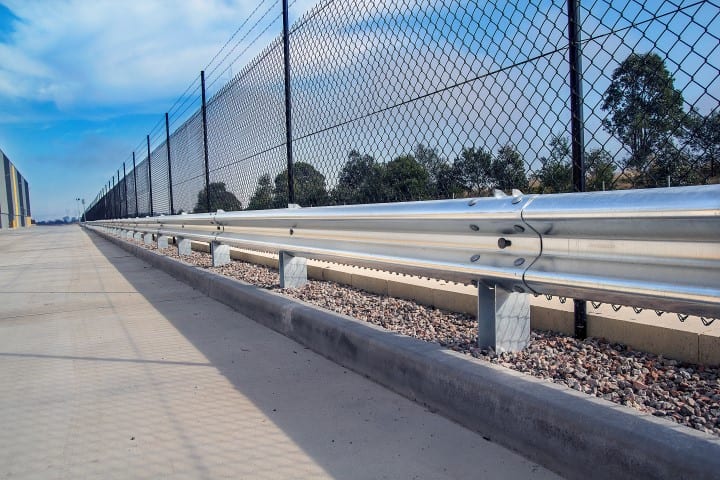 RHINO-STOP® Type 3 parking barrier systems installed around warehouse near chain fencing