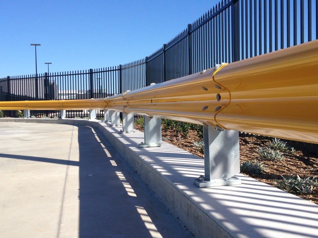 Toll car park yellow crash barrier installation near crimped security fencing